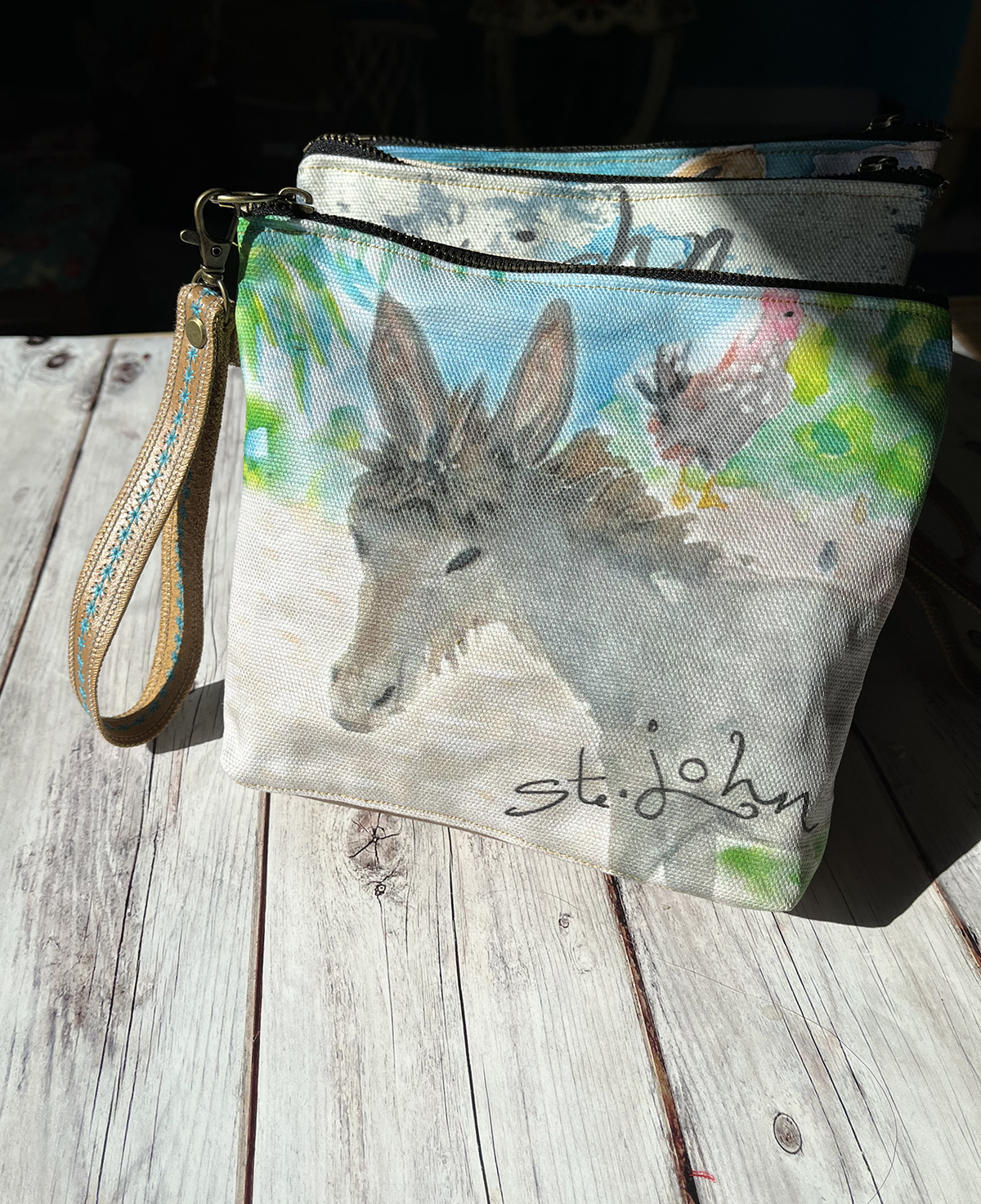 These Leather and Canvas Wristlet Bags feature a sweet baby St. John donkey. This wristlet is cotton canvas and genuine leather.